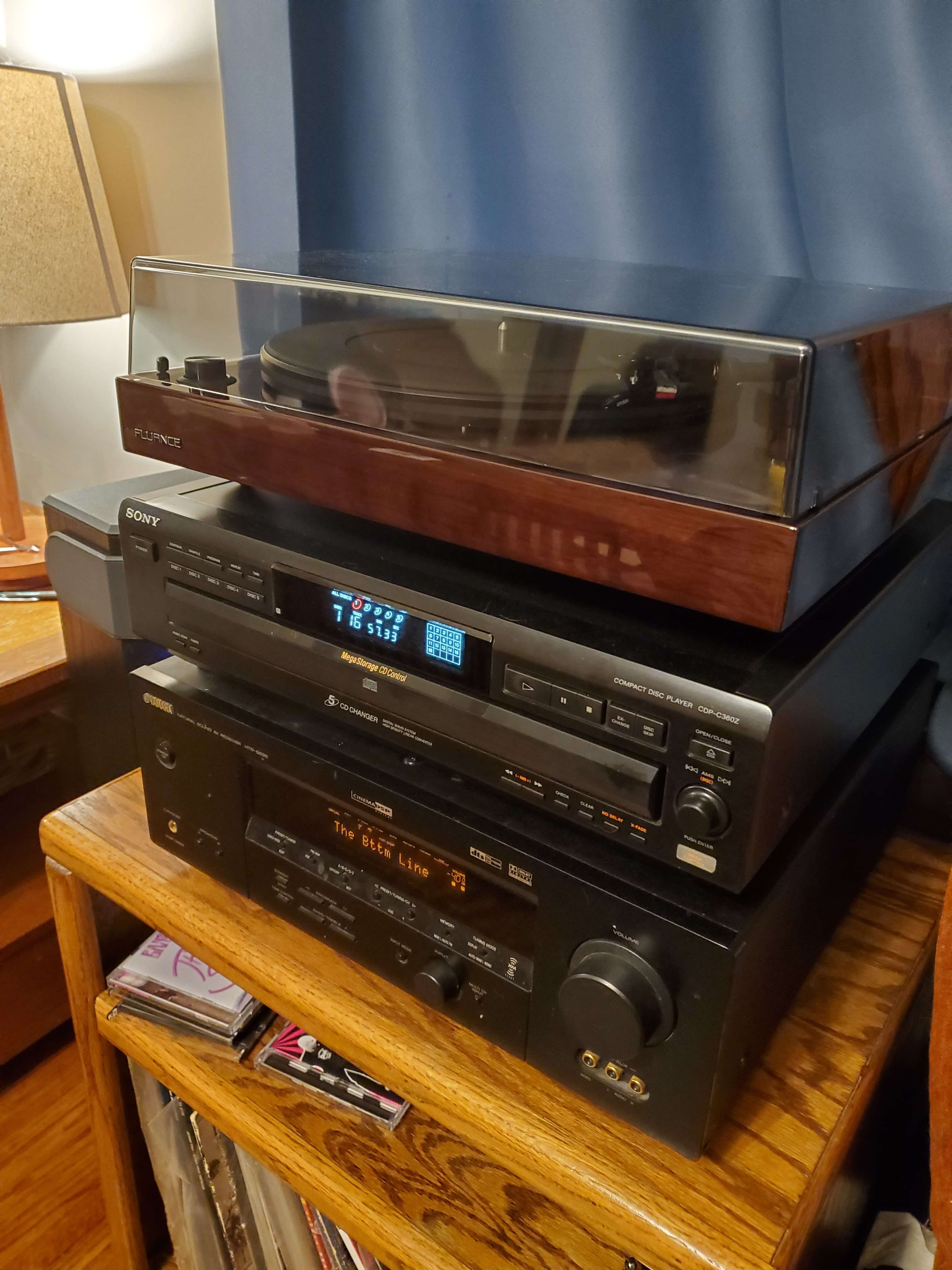 stack of three pieces of audio equipment. from bottom to top, a yamaha amplifier, a sony 5-disc cd player, and a fluance turntable with a dust cover.